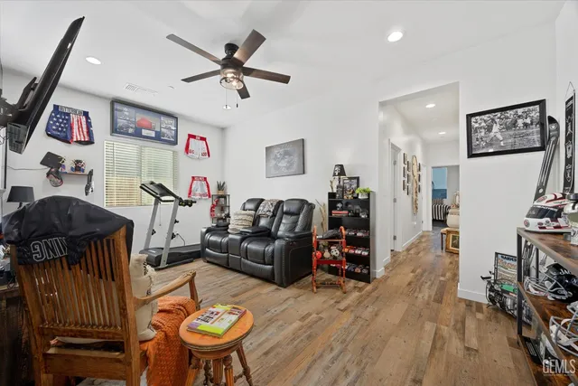 a living room with furniture a flat screen tv and a wooden floor