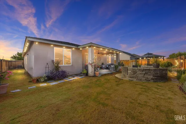 a view of a house with backyard and sitting area