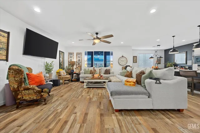 a living room with furniture kitchen view and a flat screen tv
