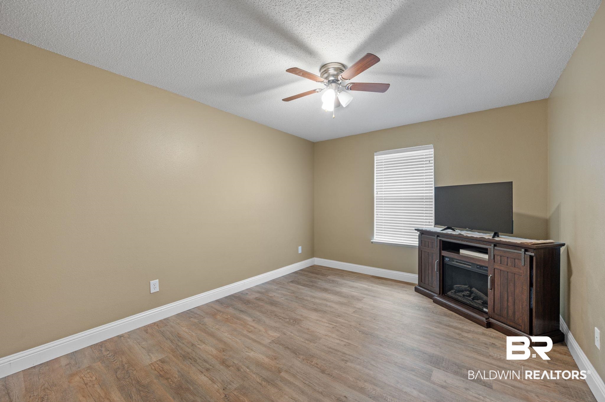 11705 Venice Boulevard Foley, AL 36535 - Photo 17 of 43 Unfurnished living room featuring light wood-type flooring, a textured ceiling, and ceiling fan