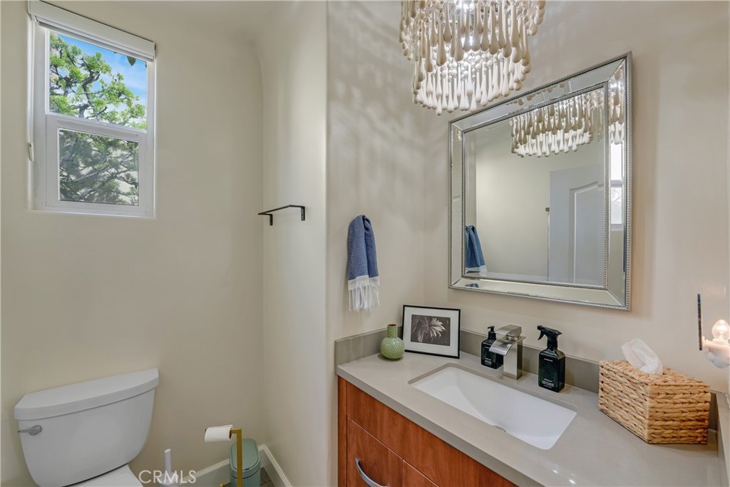 308 5th Street Huntington Beach, CA 92648 - Photo 29 of 41 a bathroom with a toilet a sink and mirror