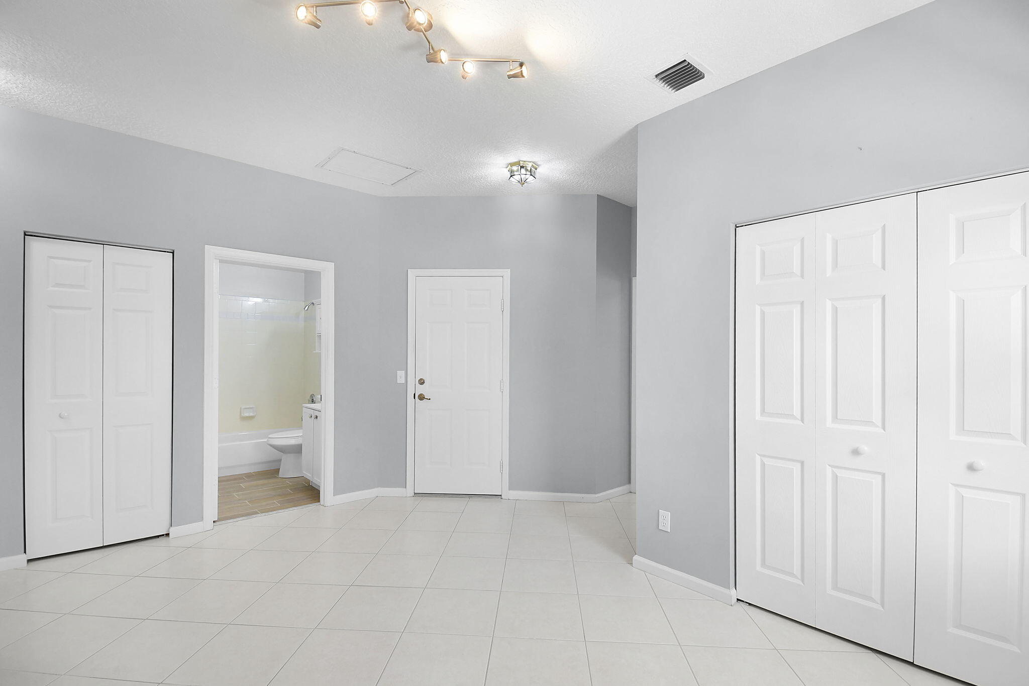 6785 Southeast Warwick Lane Stuart, FL 34997 - Photo 16 of 62 wooden floor in an empty room with a bathroom