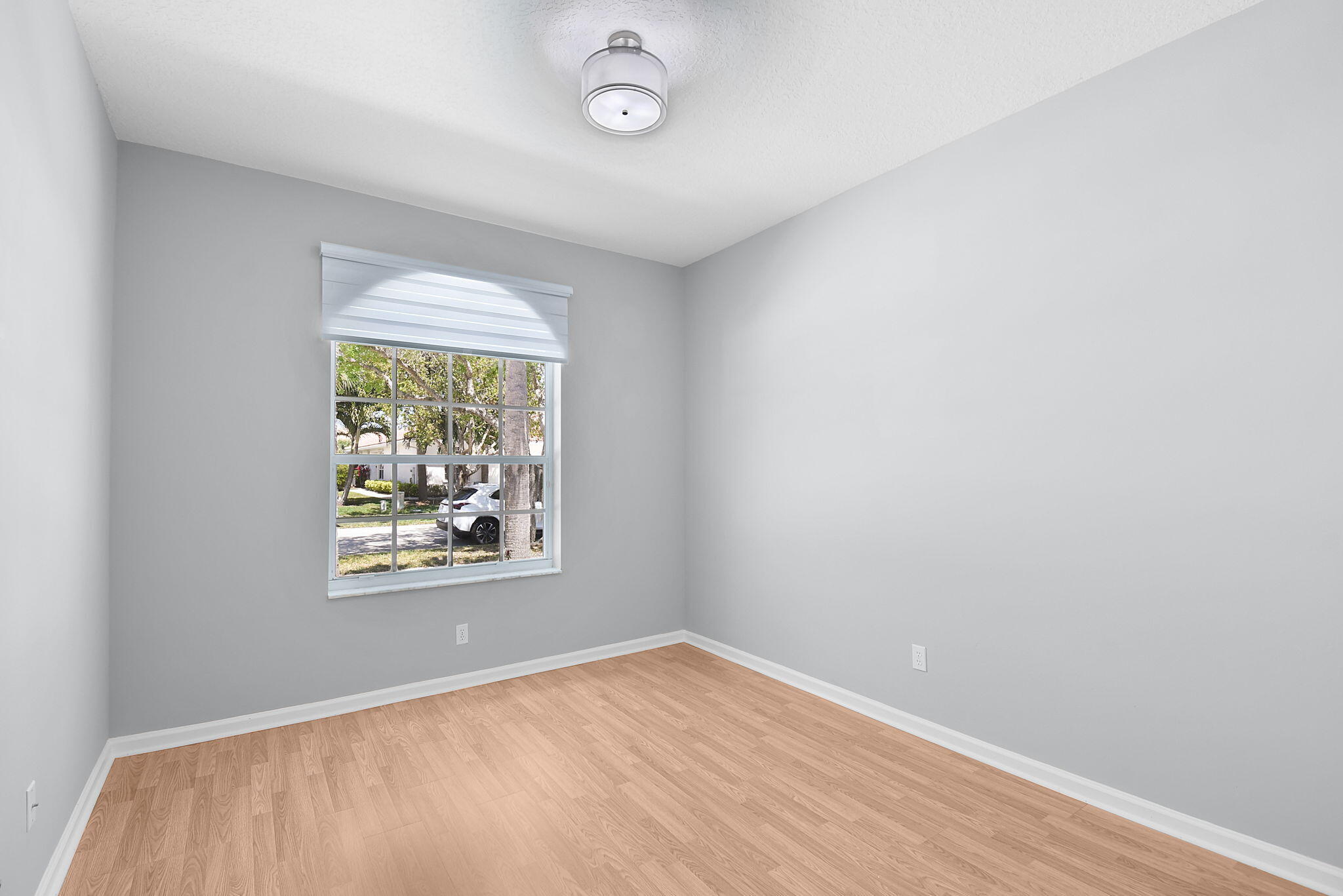 6785 Southeast Warwick Lane Stuart, FL 34997 - Photo 21 of 62 an empty room with wooden floor and windows