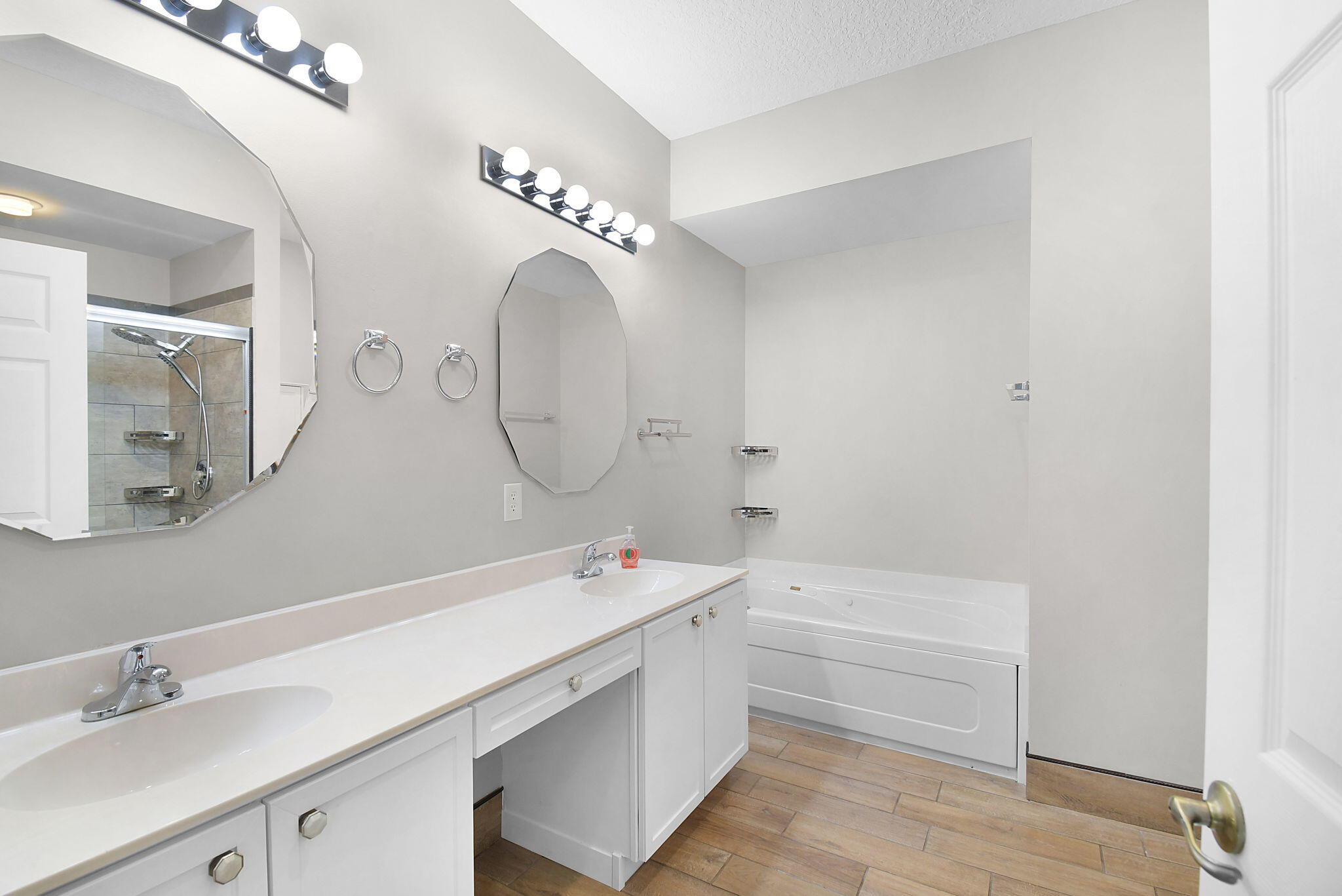 6785 Southeast Warwick Lane Stuart, FL 34997 - Photo 22 of 62 a bathroom with a tub a sink and a mirror