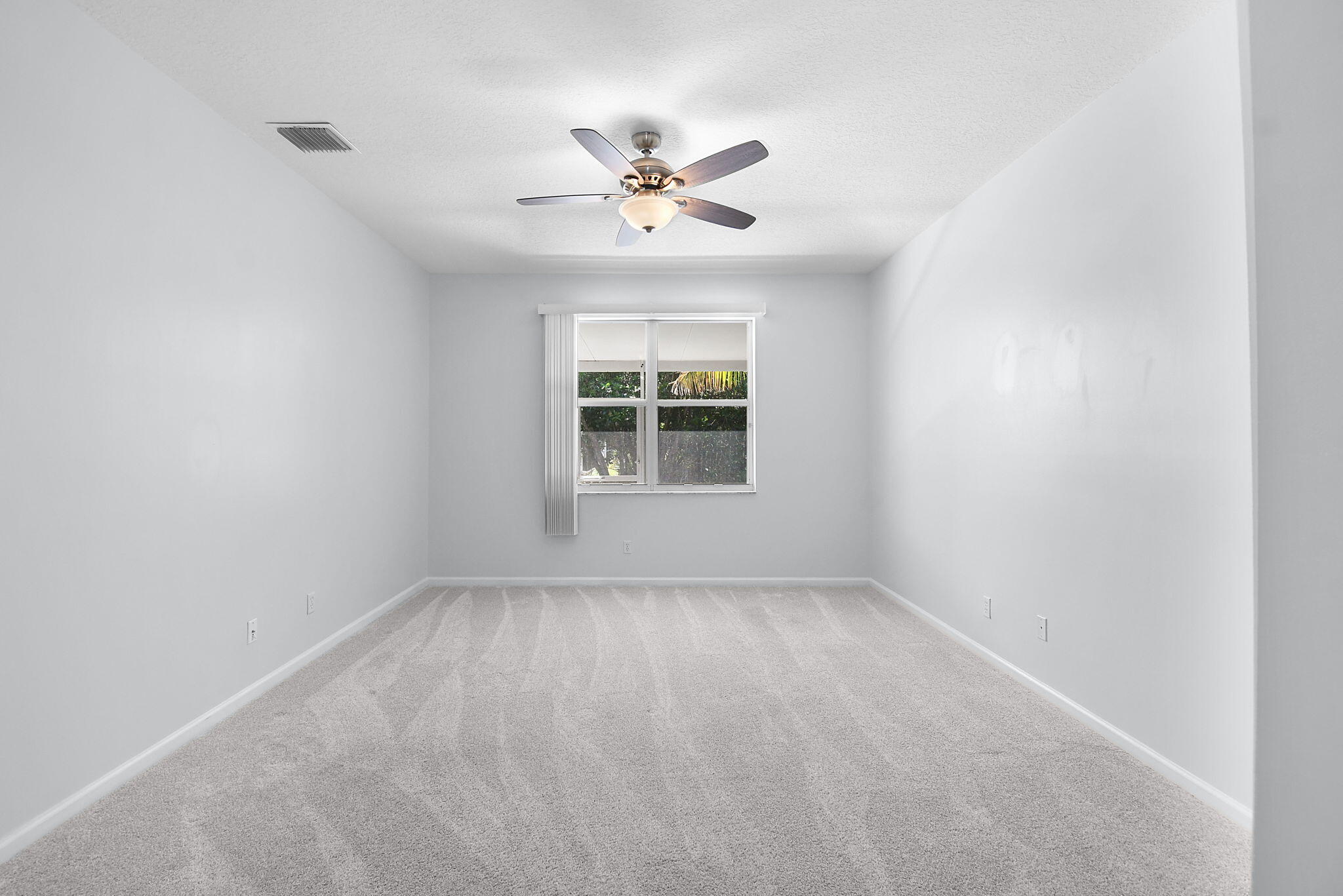 6785 Southeast Warwick Lane Stuart, FL 34997 - Photo 24 of 62 an empty room with windows and fan