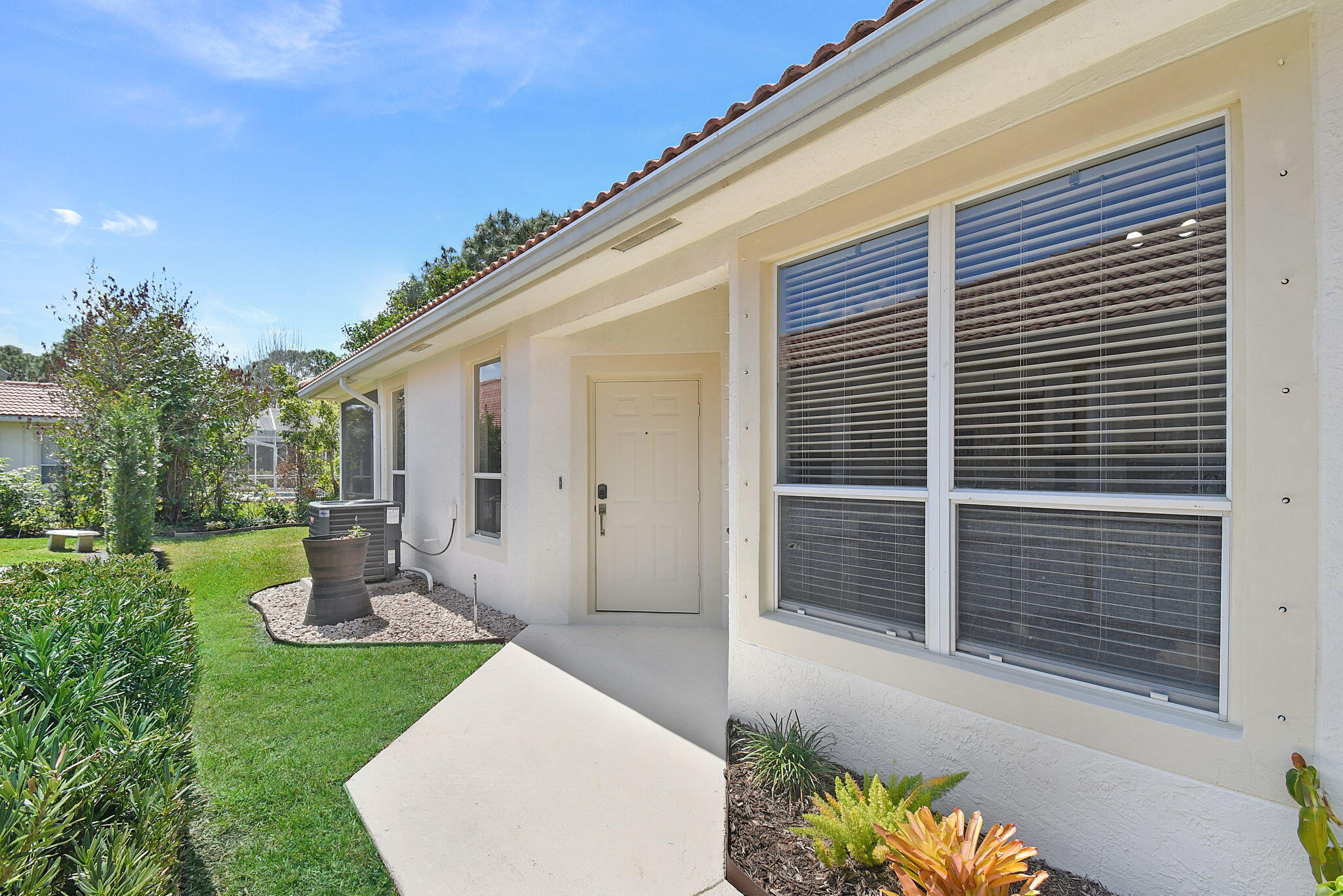 6785 Southeast Warwick Lane Stuart, FL 34997 - Photo 3 of 62 a front view of a house with garden