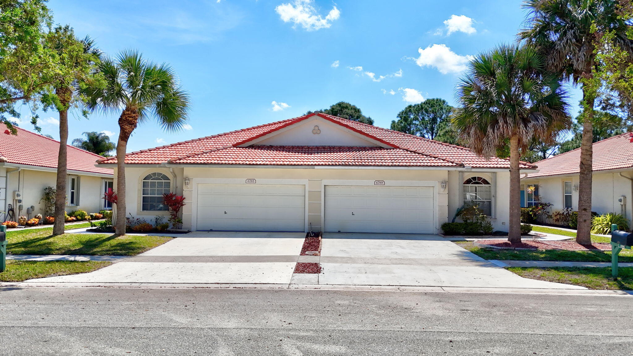 6785 Southeast Warwick Lane Stuart, FL 34997 - Photo 50 of 62 a front view of a house with a yard and garage