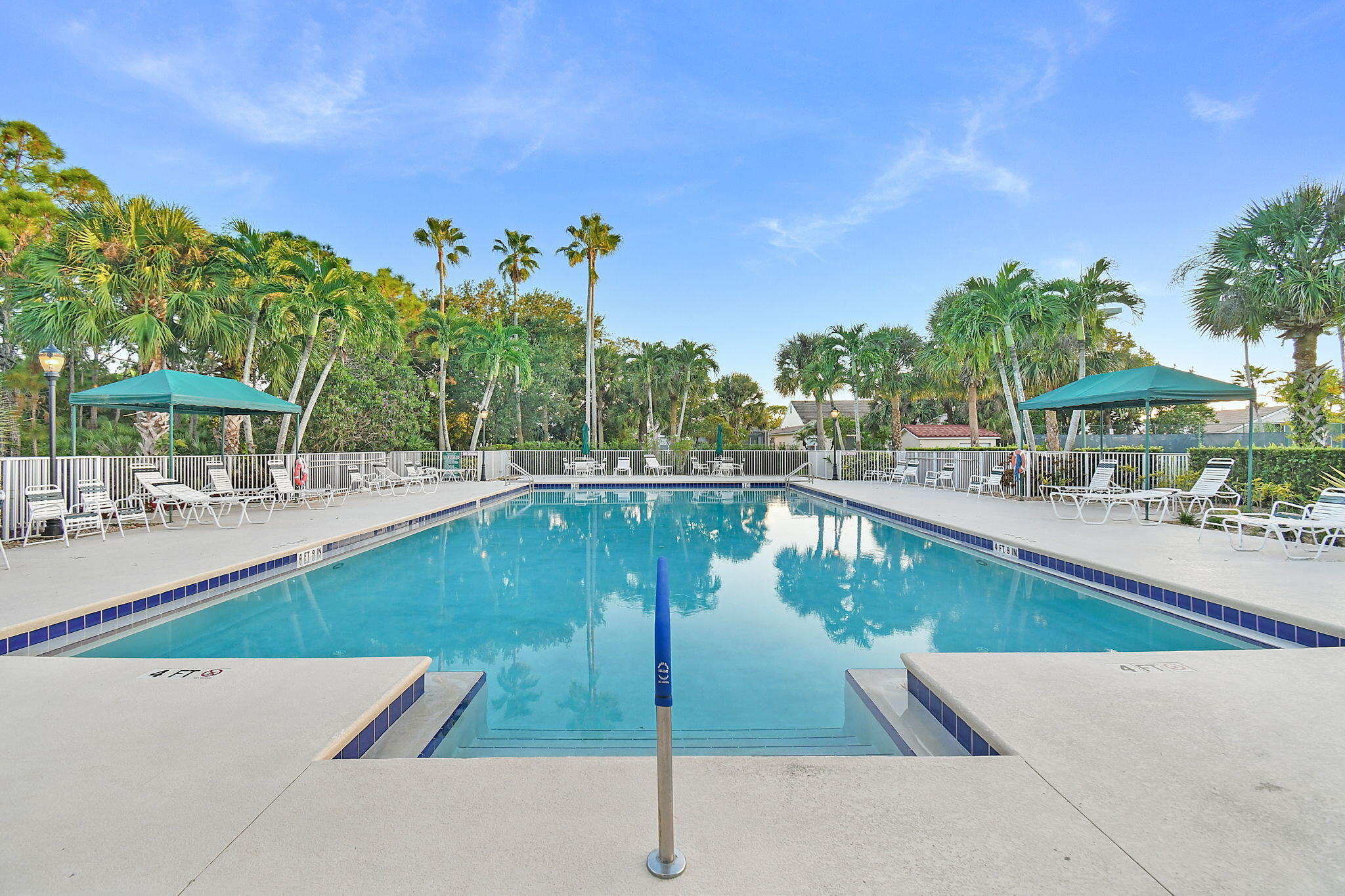 6785 Southeast Warwick Lane Stuart, FL 34997 - Photo 52 of 62 a view of a swimming pool with outdoor seating and plants