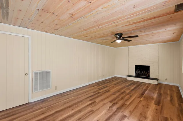 a view of an empty room with a fireplace and a window