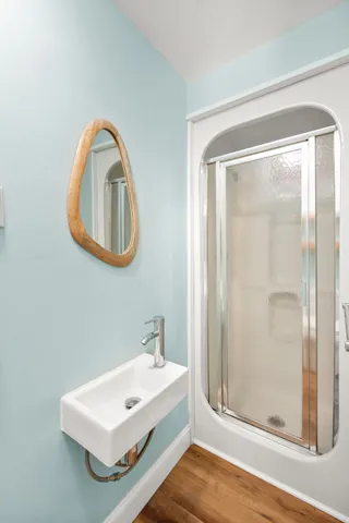 a bathroom with a sink mirror and shower