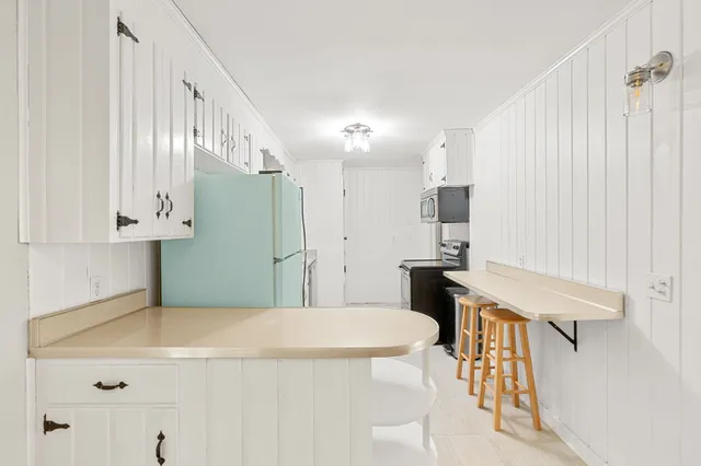 a kitchen that has a microwave a stove and a refrigerator