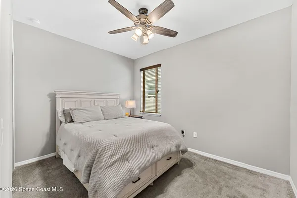a bedroom with a bed and a ceiling fan