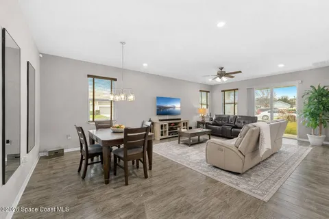 a living room with furniture a dining table and a potted plant