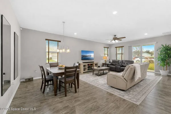 a living room with furniture a dining table and a potted plant