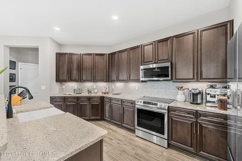 a kitchen with stainless steel appliances granite countertop wooden cabinets a stove a sink and dishwasher