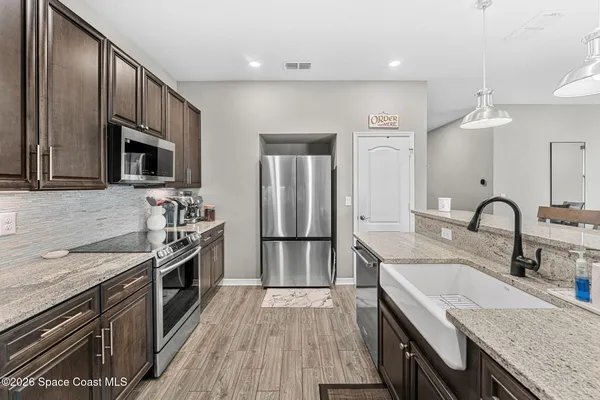 a kitchen with granite countertop stainless steel appliances and wooden cabinets