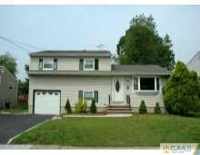 a view of a yard in front of a house with a large tree