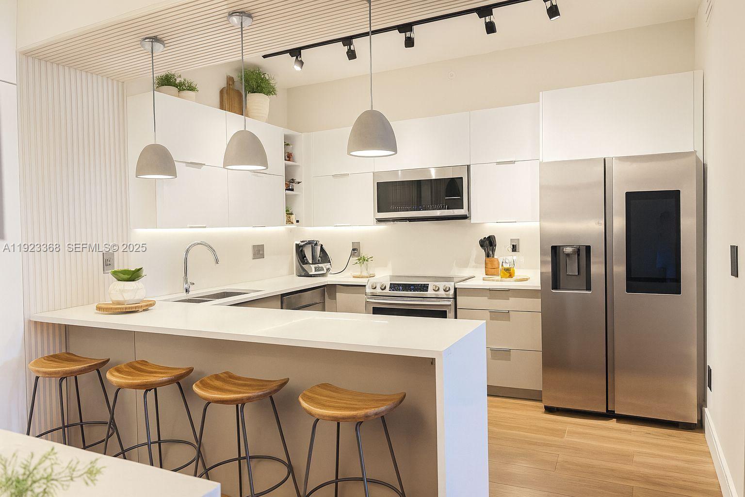 711 Crandon Boulevard, Unit 401 Key Biscayne, FL 33149 - Photo 3 of 33 a kitchen with stainless steel appliances granite countertop a sink a stove a refrigerator and island with wooden floor