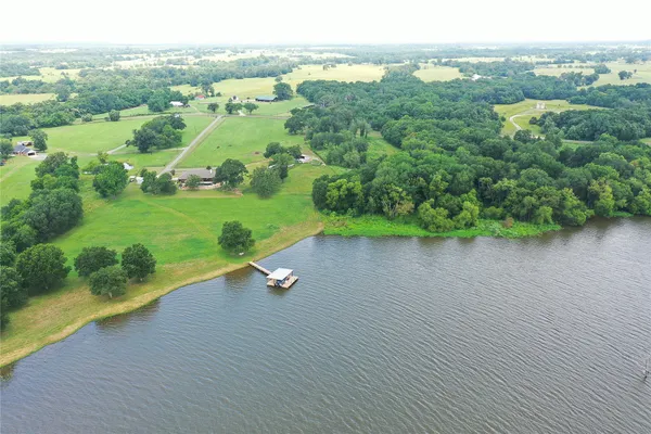 an aerial view of a house with a garden and lake view