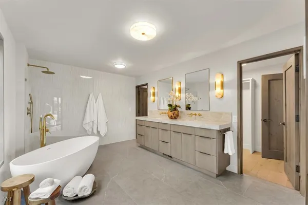 a bathroom with a granite countertop sink mirror and bathtub
