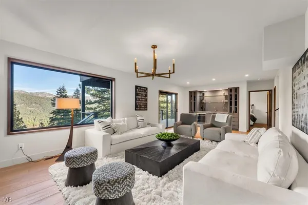 a living room with furniture large window and flat screen tv