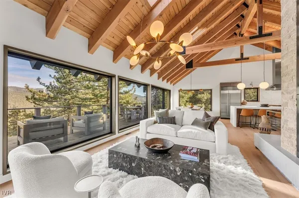a living room with furniture floor to ceiling windows and a table
