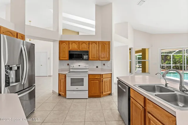 a large kitchen with stainless steel appliances granite countertop a stove a sink dishwasher and a refrigerator