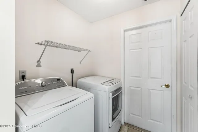 an empty room with chandelier fan and windows