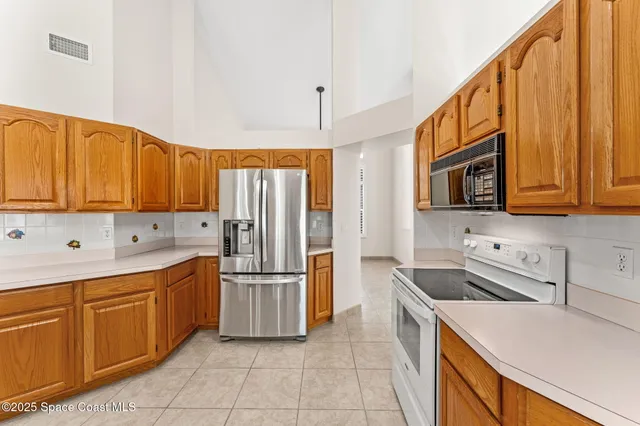 a kitchen with stainless steel appliances granite countertop a refrigerator and a stove top oven