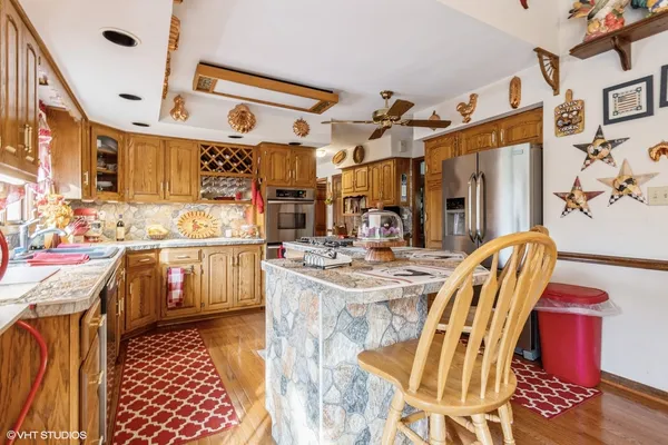 a kitchen with stainless steel appliances kitchen island granite countertop a sink and cabinets