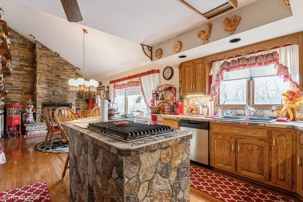 a kitchen with stainless steel appliances a stove a sink dishwasher and cabinets with wooden floor