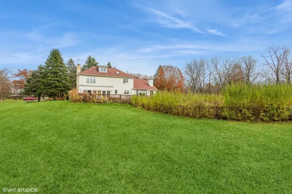 a view of a house with a big yard and large trees