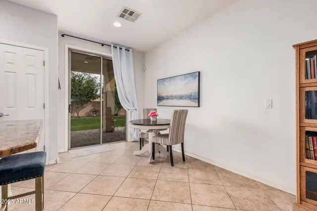 a dining room with furniture and a floor to ceiling window