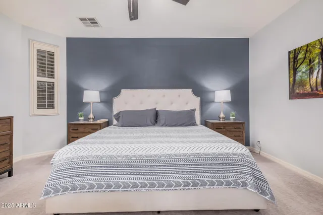 a bedroom with a bed and painting on the wall