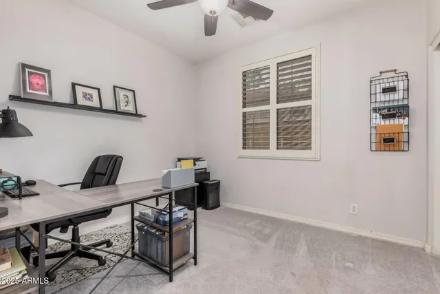 a view of a workspace with furniture and a window