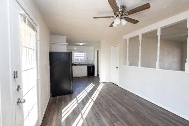a view of a kitchen with a refrigerator a ceiling fan and wooden floor