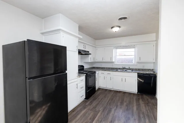 a kitchen with a refrigerator and a stove top oven