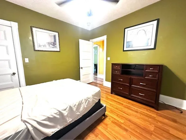 a bedroom with a bed and wooden floor