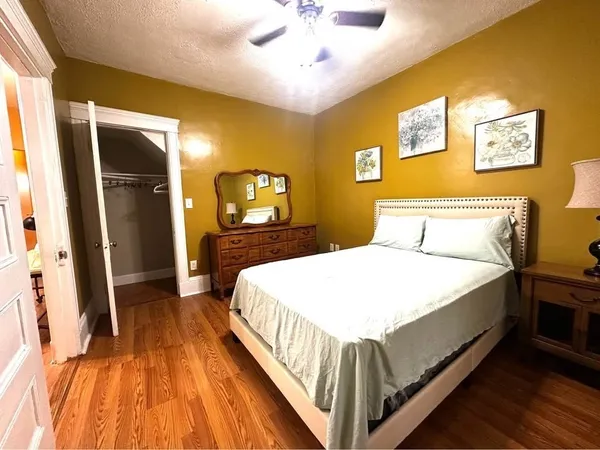 a bedroom with a bed and a flat tv screen on dresser