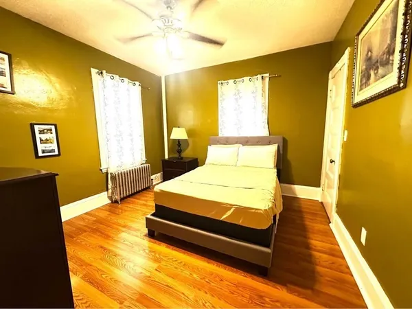 a bedroom with a bed and wooden floor