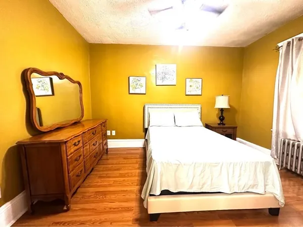 a bedroom with a bed and wooden floor
