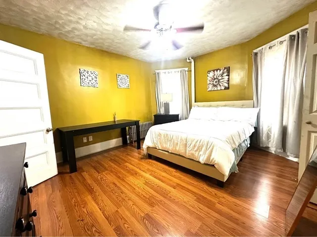 a bedroom with a bed dresser and a window