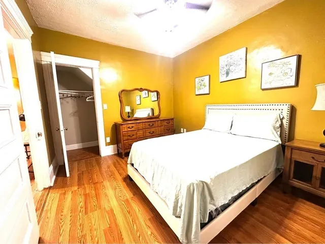 a bedroom with a bed and wooden floor