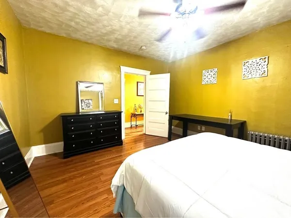 a living room with a bed and a dresser