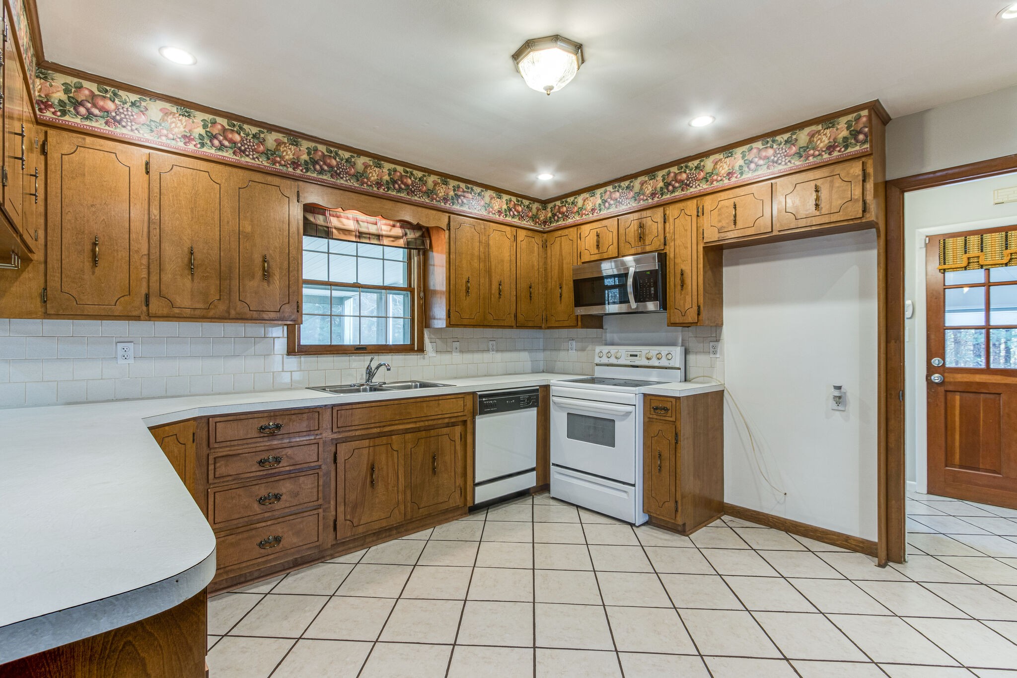 3083 Hickerson Road Manchester, TN 37355 - Photo 13 of 34 a kitchen with granite countertop a sink cabinets stainless steel appliances and a window