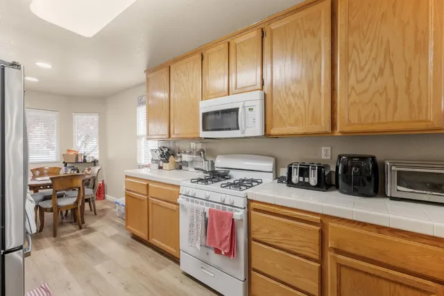 a kitchen with stainless steel appliances granite countertop a stove a sink and a microwave