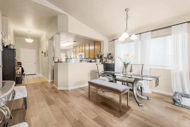 a view of a a dining room and livingroom with furniture wooden floor a chandelier