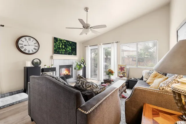 a living room with furniture a fireplace and a large window