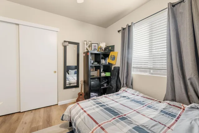 a bedroom with a bed and wooden floor