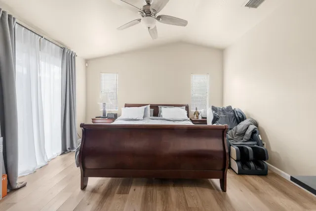 a bedroom with a bed and wooden floor